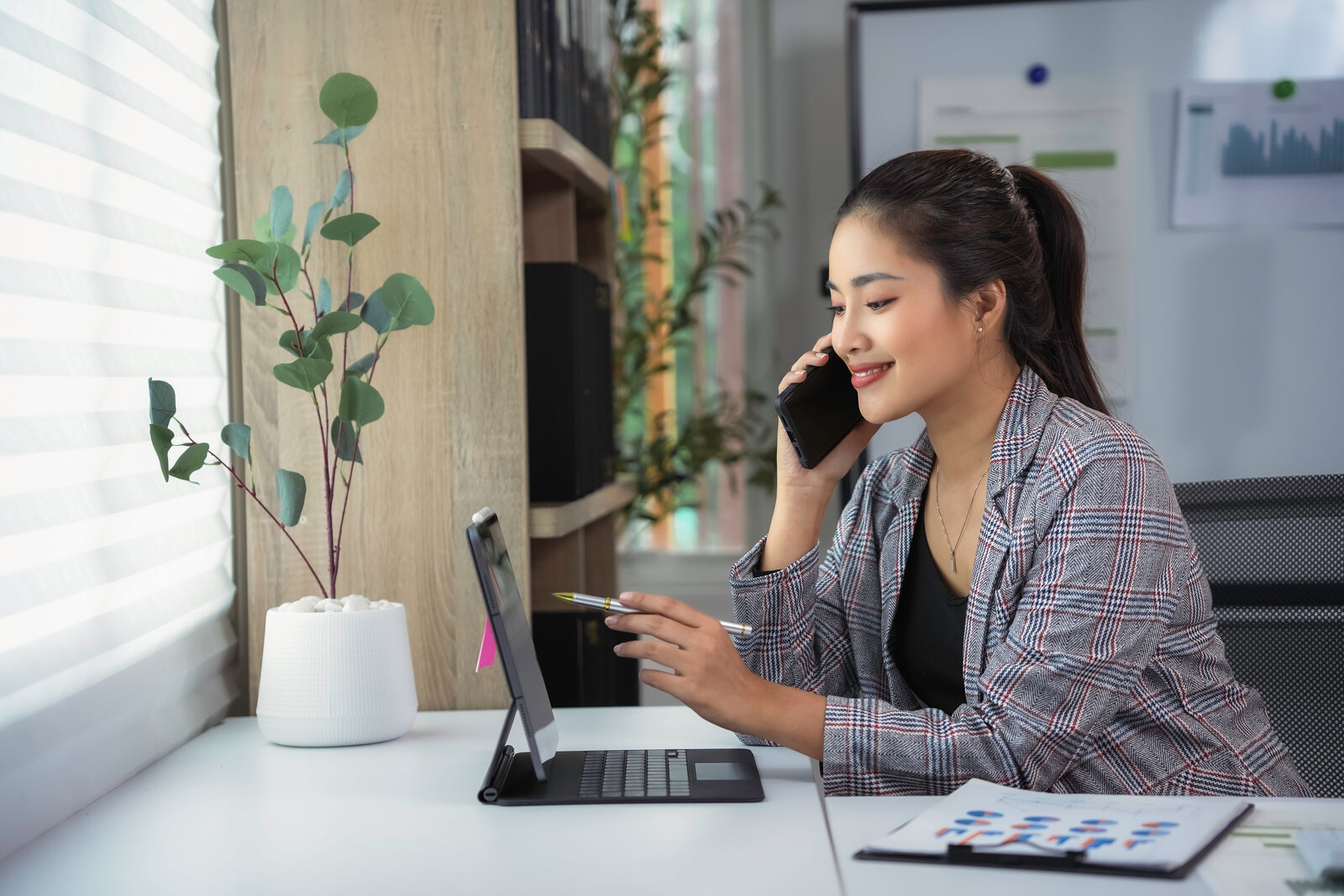 A program staff member on the phone at a desk with lease paperwork