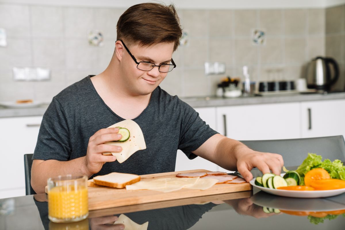 A smiling young man in a home kitchen