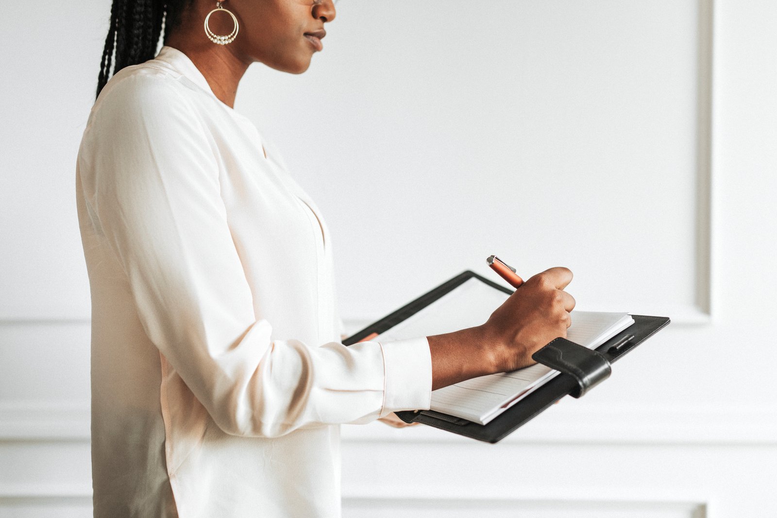 A businesswoman marking a renewal date on a desk calendar