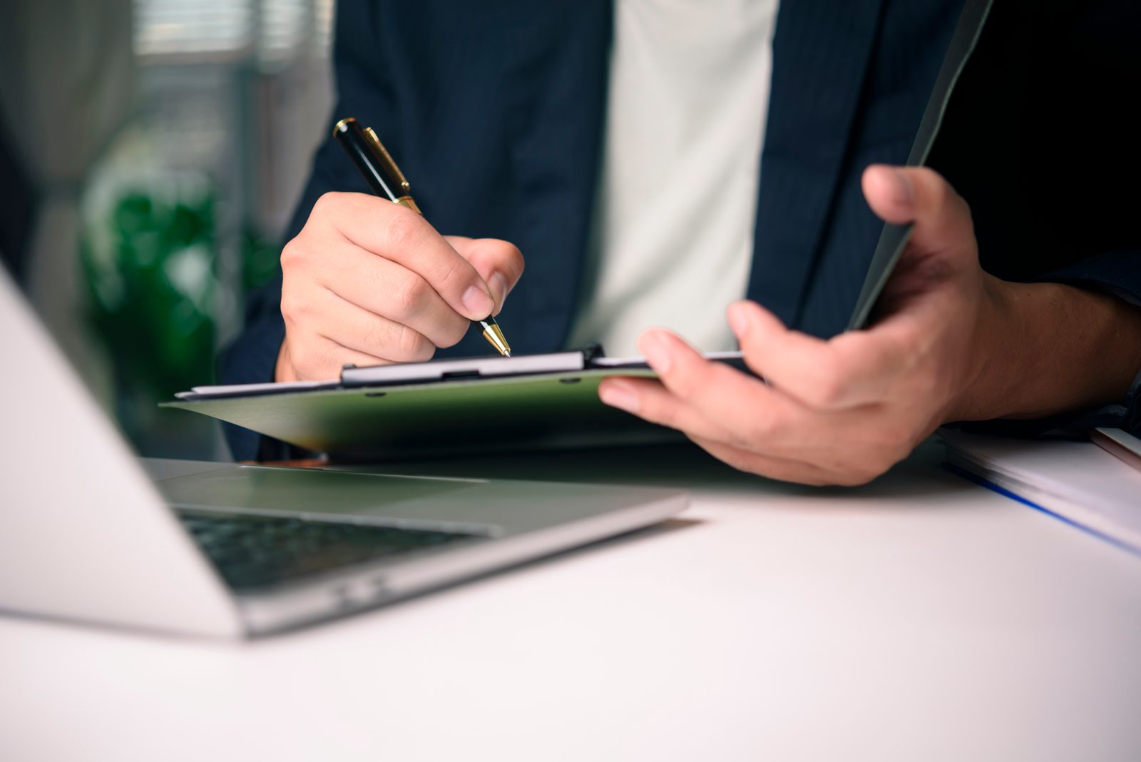 A close-up of a hand signing a lease renewal document