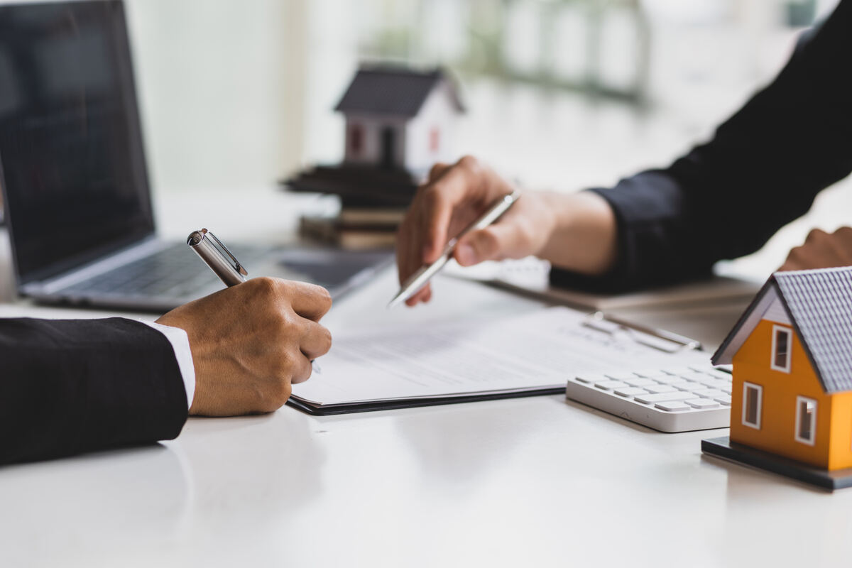 A lease agreement being reviewed and signed at a table