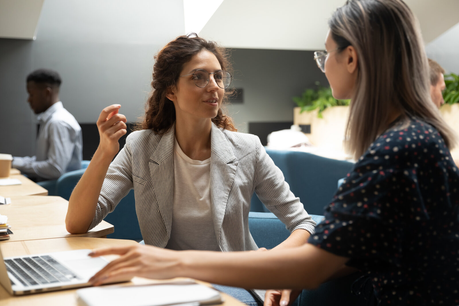 A supervisor having a supportive conversation with a colleague in an office